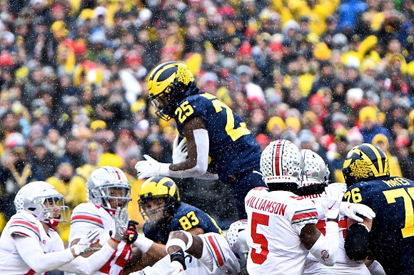 Erick All (83), Hassan Haskins (25), and Ryan Hayes (76)