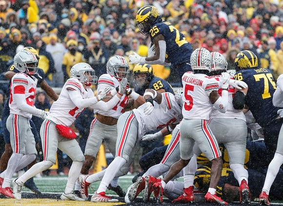 Erick All (83), Hassan Haskins (25), and Ryan Hayes (76)