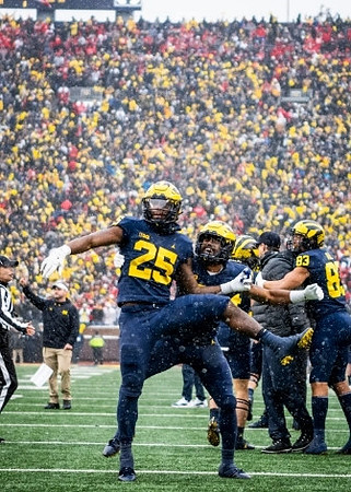 Hassan Haskins (25), Jim Harbaugh, and Erick All (83)