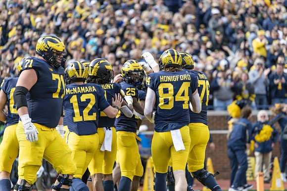 Andrew Stueber (71), Cade McNamara (12), Andrel Anthony (1), Hassan Haskins (25), Joel Honigford (84), and Ryan Hayes (76)