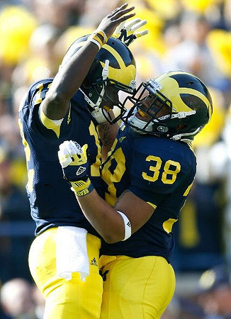 Devin Gardner (12) and Thomas Rawls (38)