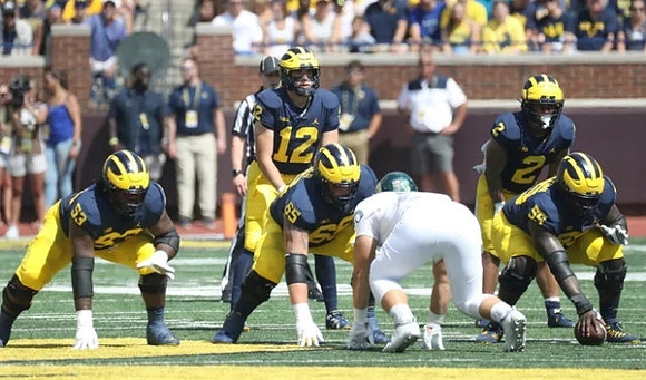 Trente Jones (53), Cade McNamara (12), Zak Zinter (65), Olusegun Oluwatimi (55), and Blake Corum (2)