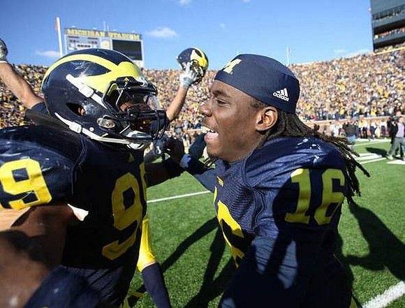 Adam Patterson (99) and Denard Robinson (16)