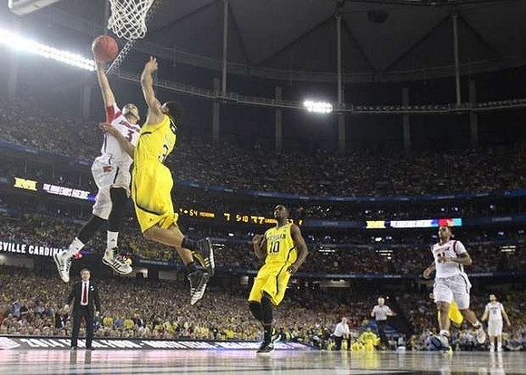 Trey Burke (3), Tim Hardaway Jr. (10), and Louisville Head Coach Rick Pitino