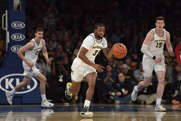 Franz Wagner (21), Zavier Simpson (3), and Jon Teske (15)