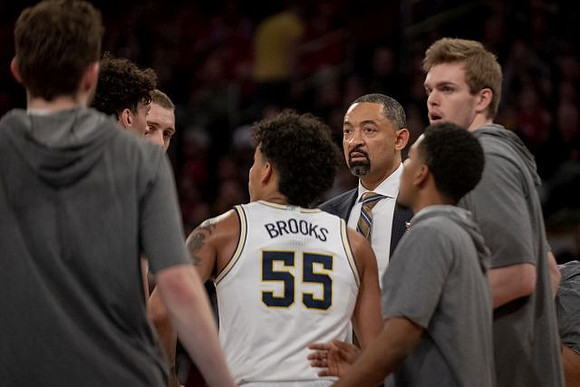 Eli Brooks (55), Juwan Howard, and Michigan Team