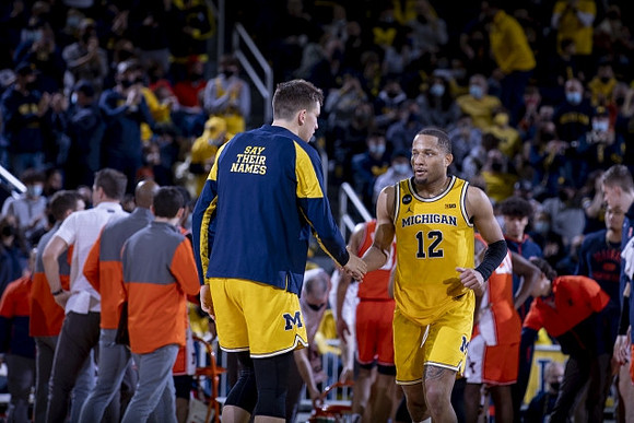 DeVante' Jones (12) and Michigan Team