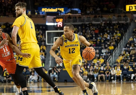 Hunter Dickinson (1) and DeVante' Jones (12)