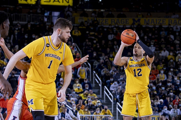 Hunter Dickinson (1) and DeVante' Jones (12)