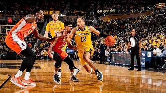 Hunter Dickinson (1) and DeVante' Jones (12)