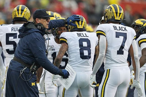 Cesar Ruiz (51), Jim Harbaugh, Ronnie Bell (8), and Tarik Black (7)