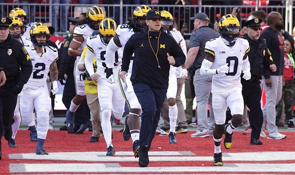 Jim Harbaugh, Mike Sainristil (0), and Michigan Team