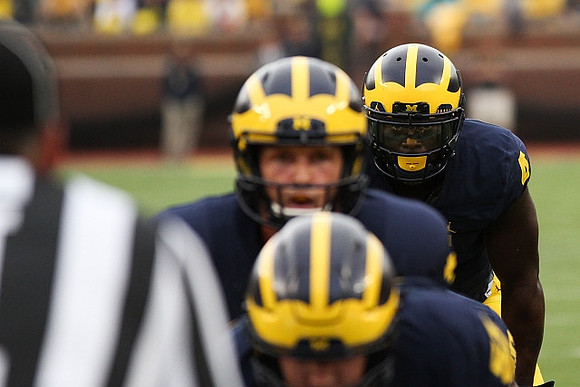 Mason Cole (52), Wilton Speight (3), and De'Veon Smith (4)