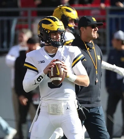 J.J. McCarthy (9) and Jim Harbaugh
