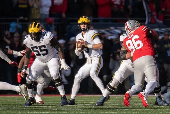 Olusegun Oluwatimi (55), J.J. McCarthy (9), and Trevor Keegan (77)