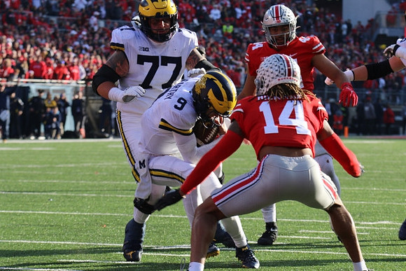 Trevor Keegan (77) and J.J. McCarthy (9)