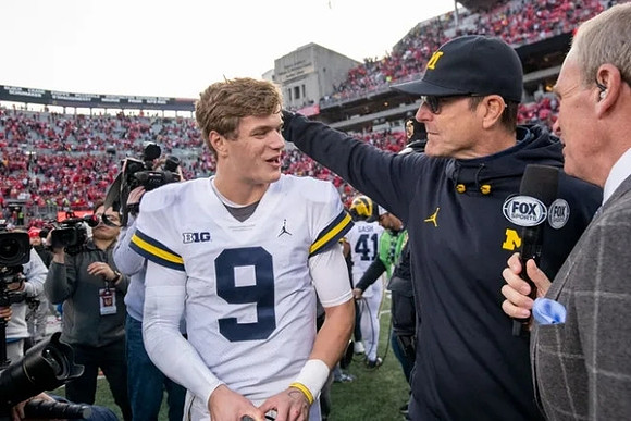 J.J. McCarthy (9) and Jim Harbaugh