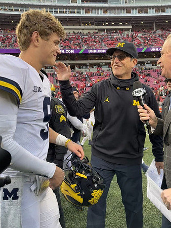 J.J. McCarthy (9) and Jim Harbaugh