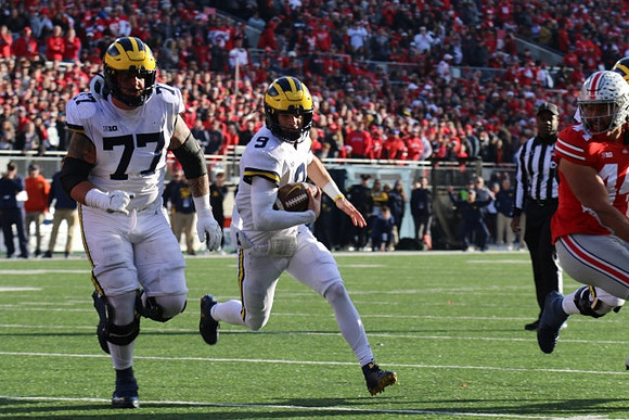 Trevor Keegan (77) and J.J. McCarthy (9)
