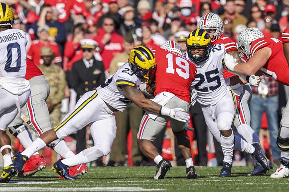 Mike Sainristil (0), Michael Barrett (23), and Junior Colson (25)