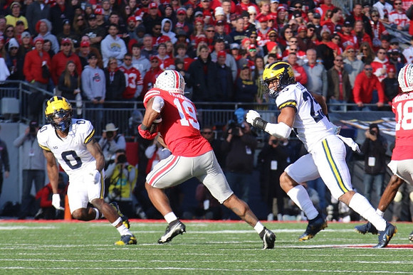 Mike Sainristil (0) and Junior Colson (25)