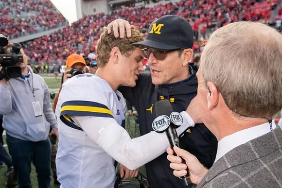 J.J. McCarthy (9) and Jim Harbaugh