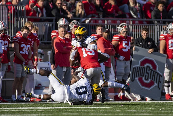 Mike Sainristil (0) and Junior Colson (25)