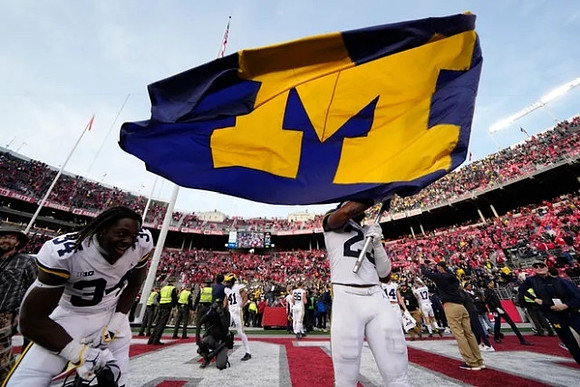 Jaydon Hood (34), Michael Barrett (23), and Michigan Team