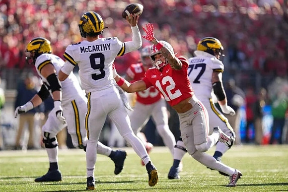 J.J. McCarthy (9) and Trevor Keegan (77)