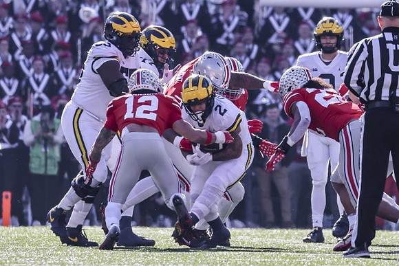 Olusegun Oluwatimi (55), Trevor Keegan (77), Blake Corum (2), and J.J. McCarthy (9)