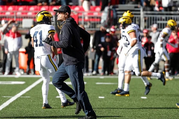 Isaiah Gash (41), Jim Harbaugh, and Michigan Team