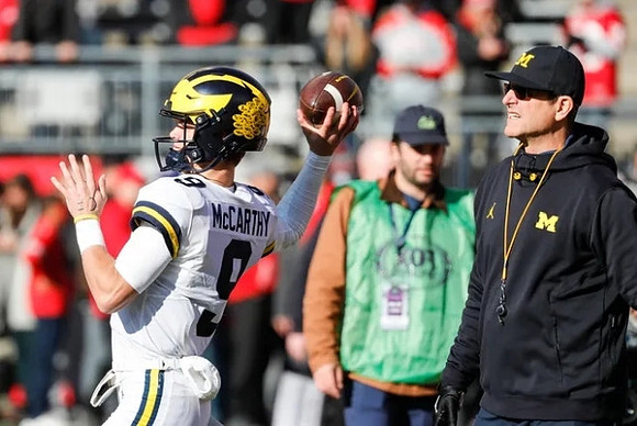 J.J. McCarthy (9) and Jim Harbaugh
