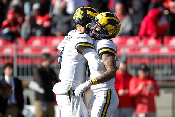 J.J. McCarthy (9) and Ronnie Bell (8)