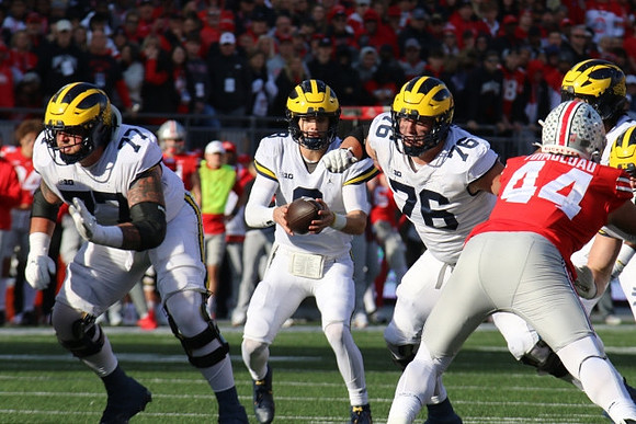 Trevor Keegan (77), J.J. McCarthy (9), and Ryan Hayes (76)