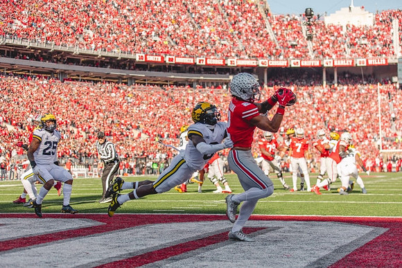 Junior Colson (25) and Mike Sainristil (0)