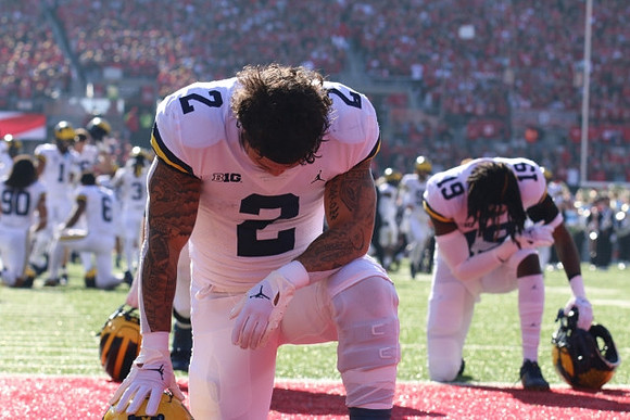 Blake Corum (2), Rod Moore (19), and Michigan Team