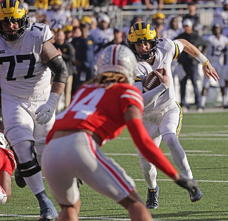 Trevor Keegan (77) and J.J. McCarthy (9)