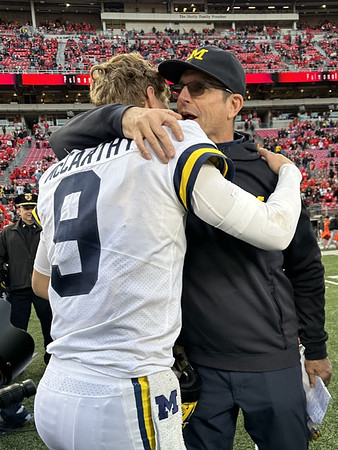J.J. McCarthy (9) and Jim Harbaugh
