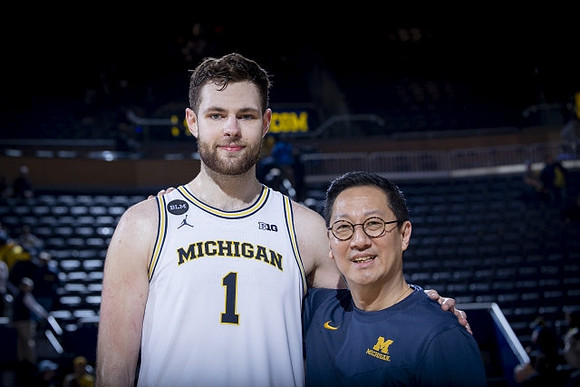 Hunter Dickinson (1) and Michigan President Santa Ono