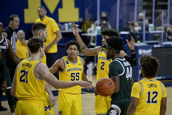 Franz Wagner (21), Hunter Dickinson (1), Eli Brooks (55), Isaiah Livers (2), and Mike Smith (12)