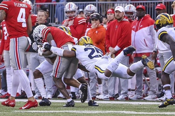 Junior Colson (25) and Mike Sainristil (0)