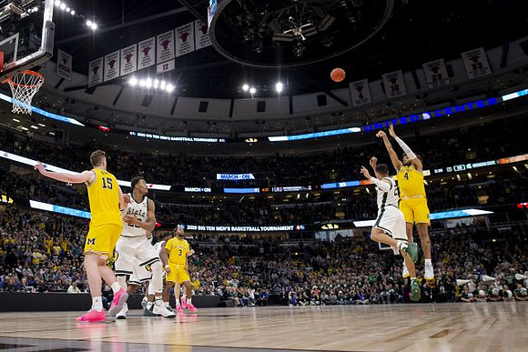 Jon Teske (15), Zavier Simpson (3), and Isaiah Livers (4)