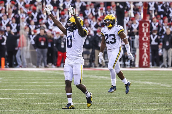 Mike Sainristil (0) and Michael Barrett (23)