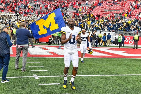 Mike Sainristil (0) and Michael Barrett (23)