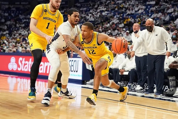 Hunter Dickinson (1), DeVante' Jones (12), and Penn State Head Coach Micah Shrewsberry