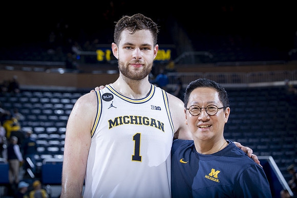Hunter Dickinson (1) and Michigan President Santa Ono