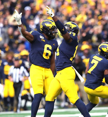Josh Uche (6), Josh Metellus (14), and Khaleke Hudson (7)