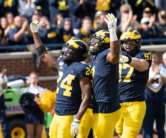 Lavert Hill (24), Khaleke Hudson (7), and Aidan Hutchinson (97)