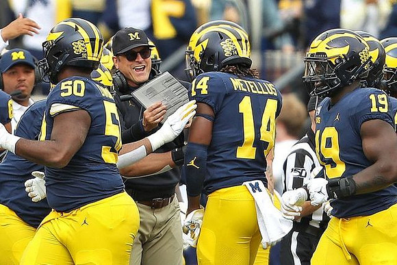 Josh Gattis, Michael Dwumfour (50), Jim Harbaugh, Josh Metellus (14), and Kwity Paye (19)