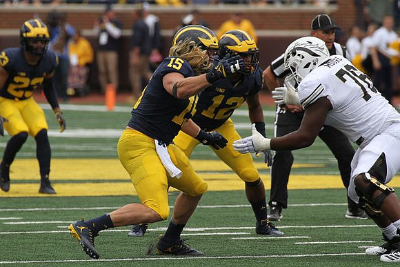 Tyree Kinnel (23), Chase Winovich (15), and Josh Ross (12)